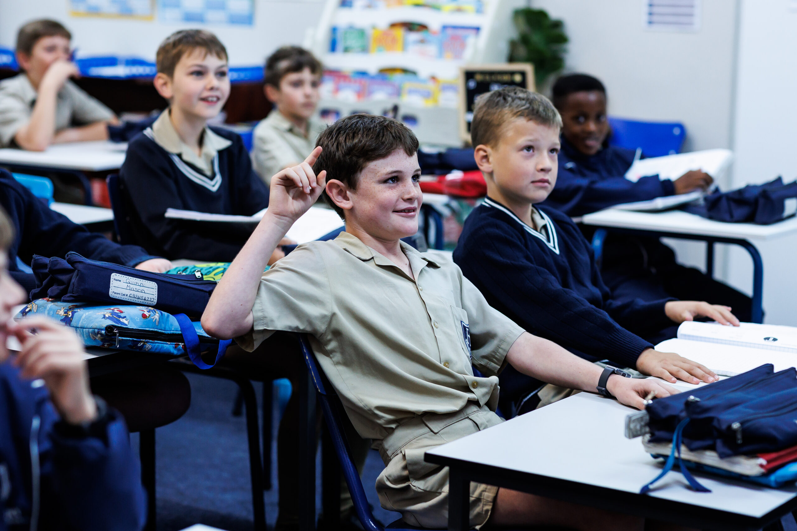 Highbury boys engaged in a classroom lesson, with one pupil raising his hand to answer a question.